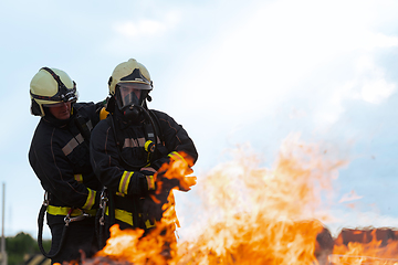 Image showing Firefighters fight the fire flame to control fire not to spreading out. Firefighter industrial and public safety concept. Traffic or car accident rescue and help action.