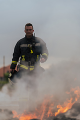 Image showing Portrait of a heroic fireman in a protective suit. Firefighter in fire fighting operation.