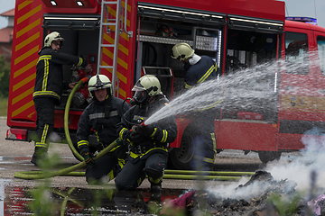 Image showing Firefighters fight the fire flame to control fire not to spreading out. Firefighter industrial and public safety concept. Traffic or car accident rescue and help action.