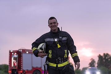 Image showing Portrait of a heroic fireman in a protective suit. Firefighter in fire fighting operation.