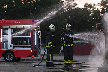 Image showing Firefighters fight the fire flame to control fire not to spreading out. Firefighter industrial and public safety concept. Traffic or car accident rescue and help action.