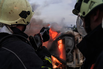 Image showing Firefighters fight the fire flame to control fire not to spreading out. Firefighter industrial and public safety concept. Traffic or car accident rescue and help action.