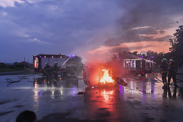 Image showing Firefighters fight the fire flame to control fire not to spreading out. Firefighter industrial and public safety concept. Traffic or car accident rescue and help action.