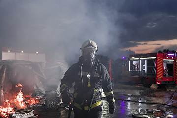 Image showing Portrait of a heroic fireman in a protective suit. Firefighter in fire fighting operation.