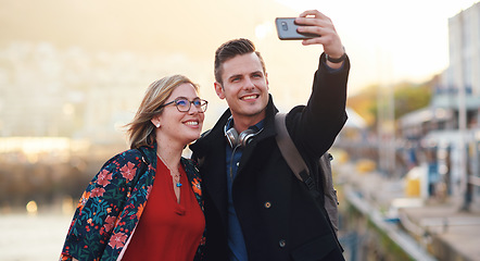 Image showing Selfie, travel and couple with phone by harbor enjoying vacation, holiday and honeymoon in Amsterdam. Journey, adventure and happy people take picture for social media, post and memory on smartphone