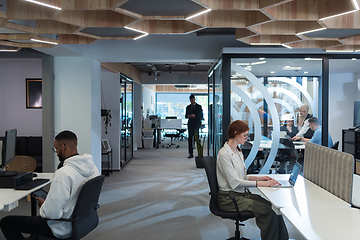 Image showing Young group of business people brainstorming together in a startup space, discussing business projects, investments, and solving challenges.