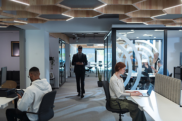 Image showing Young group of business people brainstorming together in a startup space, discussing business projects, investments, and solving challenges.