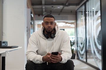 Image showing In a modern office setting, an African American businessman is diligently working on his laptop, embodying determination, ambition, and productivity in his professional environmen