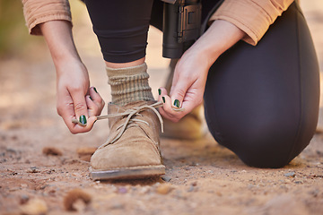 Image showing Shoes, hiking and woman tying laces to start a walk, adventure or trekking in nature of Norway. Ready, active and feet and hands of a girl walking on ground in the mountains for exercise and cardio