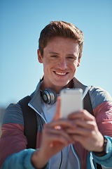 Image showing Selfie, travel and man smile outdoor with happiness from travel and freedom by blue sky. Profile picture, social media update and web networking of young person with mobile connection in the sun