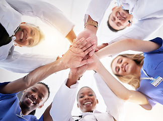 Image showing Hands, healthcare and a team of doctors in a huddle in the hospital together from below. Medical, diversity and solidarity with a medicine professional group standing in a circle in a clinic