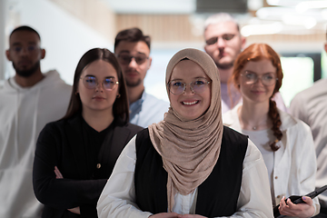 Image showing A group of young business professionals stands together, taking a well-deserved break from their busy workday, showcasing camaraderie, teamwork, and a moment of relaxation in their dynamic workplace