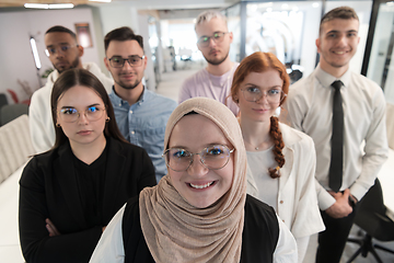 Image showing A group of young business professionals stands together, taking a well-deserved break from their busy workday, showcasing camaraderie, teamwork, and a moment of relaxation in their dynamic workplace