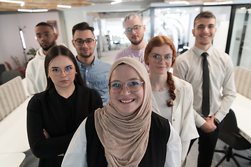 Image showing A group of young business professionals stands together, taking a well-deserved break from their busy workday, showcasing camaraderie, teamwork, and a moment of relaxation in their dynamic workplace