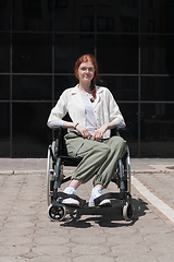 Image showing In front of a modern corporate building, a young woman sitting in a wheelchair confidently, symbolizing empowerment, inclusivity, and the strength to overcome challenges in the business world