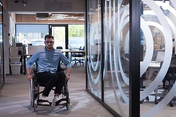 Image showing In a large modern corporation, a determined businessman in a wheelchair navigates through a hallway, embodying empowerment and inclusivity in the corporate world.