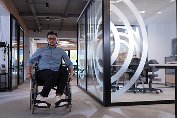 Image showing In a large modern corporation, a determined businessman in a wheelchair navigates through a hallway, embodying empowerment and inclusivity in the corporate world.