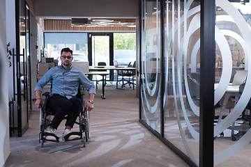 Image showing In a large modern corporation, a determined businessman in a wheelchair navigates through a hallway, embodying empowerment and inclusivity in the corporate world.