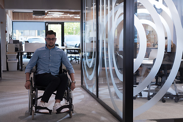 Image showing In a large modern corporation, a determined businessman in a wheelchair navigates through a hallway, embodying empowerment and inclusivity in the corporate world.