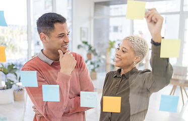 Image showing Creative people, planning schedule and smile for team strategy in brainstorming on glass wall at office. Happy man and woman employees in project plan, tasks and post it for sticky note or startup