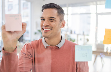 Image showing Creative man, writing and planning schedule, strategy or brainstorming on glass wall at office. Happy employee worker in project plan, tasks and write for post it or sticky note smiling for startup