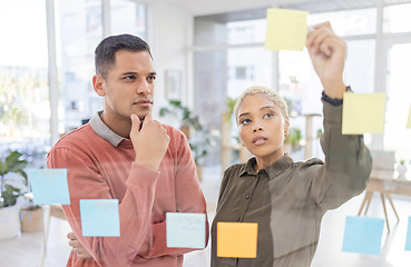 Image showing Creative people, planning and thinking for schedule, team strategy or brainstorming on glass wall at office. Man and woman in teamwork contemplating plan, tasks and post it for sticky note or startup