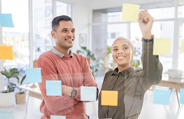 Image showing Creative people, planning schedule and strategy in brainstorming on glass wall at the office. Happy man and woman employees in project plan, tasks and post it with smile for sticky note or startup