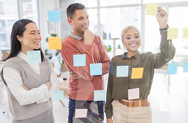 Image showing Creative people, schedule and team in planning strategy or brainstorming on glass wall at office. Group in teamwork with smile for project plan, tasks and post it for sticky note or startup together