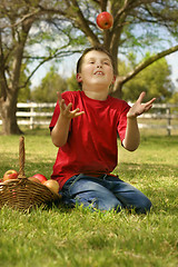 Image showing Child throwing up an apple