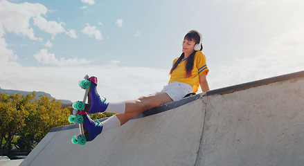 Image showing Peace, music and rollerblades with woman in skate park for summer break, streaming and sports. Fitness, relax and skating with girl listening to headphones in outdoors for hobby, freedom and health