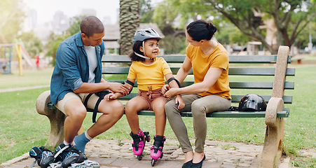 Image showing Family, rollerskate and interracial parents help kid with safety pads teaching her skating at the park and bonding outdoors. Mother, father and daughter learning to skate from mom and dad