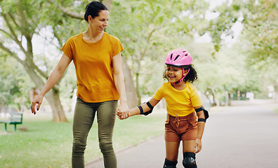 Image showing Mom, park and holding hands to rollerskate with child with care, learning and support. Interracial parent, teaching and woman with girl kid, smile and helping hand on road for skating on vacation