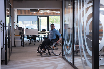 Image showing In a large modern corporation, a determined businessman in a wheelchair navigates through a hallway, embodying empowerment and inclusivity in the corporate world.