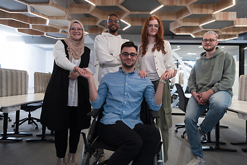 Image showing Young businessmen in a modern office extend a handshake to their business colleague in a wheelchair, showcasing inclusivity, support, and unity in the corporate environment.