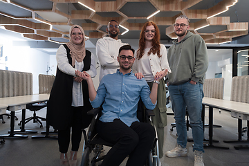 Image showing Young businessmen in a modern office extend a handshake to their business colleague in a wheelchair, showcasing inclusivity, support, and unity in the corporate environment.