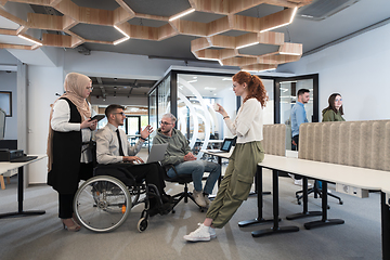 Image showing Young group of business people brainstorming together in a startup space, discussing business projects, investments, and solving challenges.