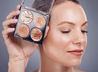 Image showing Makeup pallet, woman with face and beauty with cosmetics product, foundation and eye powder on studio background. Smile, cosmetic care and cosmetology, eyeshadow or blush, closeup and advertising