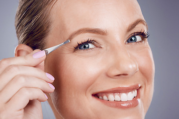 Image showing Eyebrows, cosmetic and portrait of a woman with a tweezers isolated on a grey studio background. Beauty, treatment and happy model plucking hair from face for shaping and grooming on a backdrop
