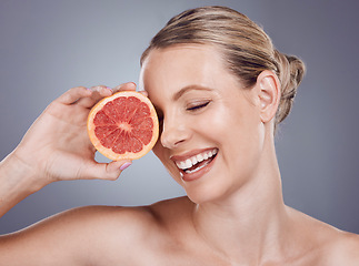 Image showing Grapefruit, laughing face and woman with beauty on studio background, wellness benefits or smile. Happy model, citrus fruits and diet for natural detox, healthy skincare or vitamin c aesthetic