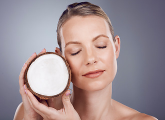 Image showing Coconut, woman and skincare for wellness in studio, healthy food and aesthetic face benefits. Beauty model, tropical fruits for oil and natural cosmetics of facial nutrition, glow and spa background