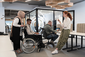 Image showing Young group of business people brainstorming together in a startup space, discussing business projects, investments, and solving challenges.