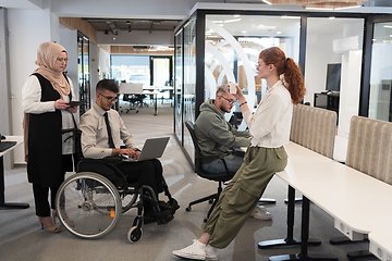 Image showing Young group of business people brainstorming together in a startup space, discussing business projects, investments, and solving challenges.