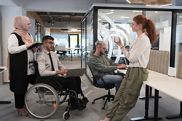 Image showing Young group of business people brainstorming together in a startup space, discussing business projects, investments, and solving challenges.