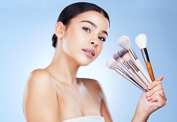 Image showing Makeup, beauty brushes and portrait of woman on blue background for cosmetics, powder and foundation. Cosmetology, salon aesthetic and face of girl with tools for application, wellness and skin glow