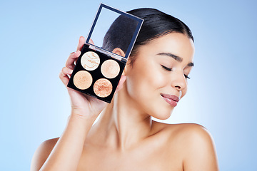Image showing Makeup, beauty and face of woman with palette on blue background for cosmetics, powder and foundation. Skincare, cosmetology and girl with highlighter for glowing skin, self care and luxury style