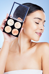 Image showing Beauty, makeup and woman with palette and smile on blue background for cosmetics, powder and foundation. Skincare, spa aesthetic and face of girl with cosmetology highlighter, product and facial glow