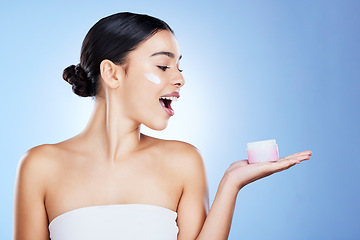 Image showing Woman, face and surprise for skincare moisturizer, cosmetics or beauty against a blue studio background. Portrait of happy female shocked with product, lotion or cream for facial treatment on mockup