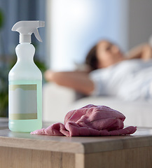 Image showing Cleaning, covid or hygiene with supplies in a house with a woman cleaner taking a break in the background. Home, product and housekeeping with a spray, disinfectant or sanitizer for health and safety