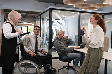 Image showing Young group of business people brainstorming together in a startup space, discussing business projects, investments, and solving challenges.