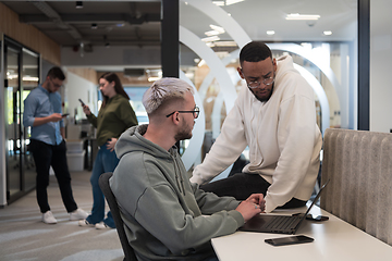 Image showing Young group of business people brainstorming together in a startup space, discussing business projects, investments, and solving challenges.